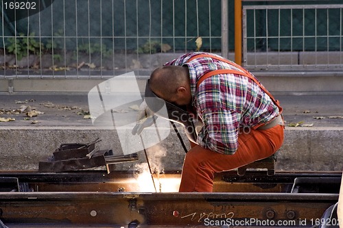 Image of Construction Worker Fixing Rails (Landscape)