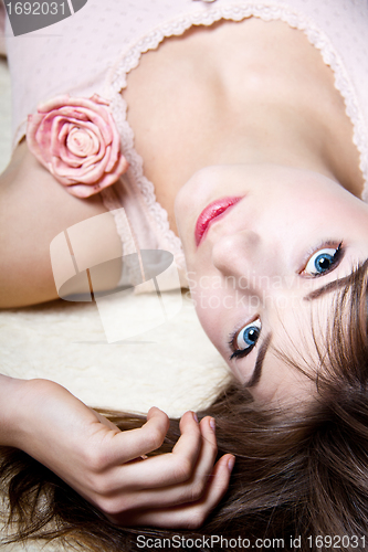 Image of young beautiful woman is sitting an a sofa and relaxing