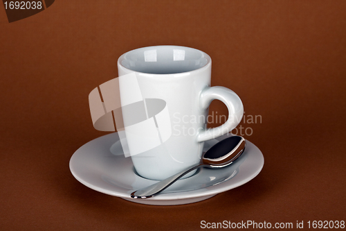 Image of white coffe cup with coffe beans and a silver spoon