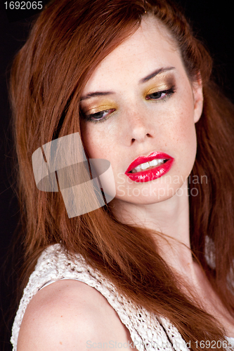 Image of portrait of a beautiful young woman with red hair and red lips