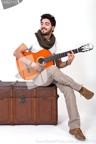 Image of young man is playing a guitar and singing