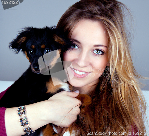 Image of young beatiful girl with a cute little dog having fun