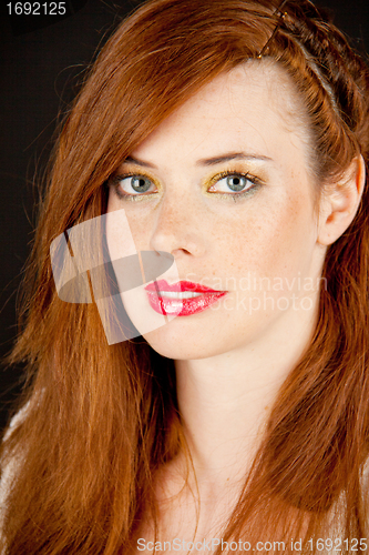 Image of portrait of a beautiful young woman with red hair and red lips