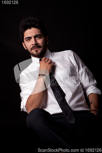 Image of young successful business man with a suit isolated on black background