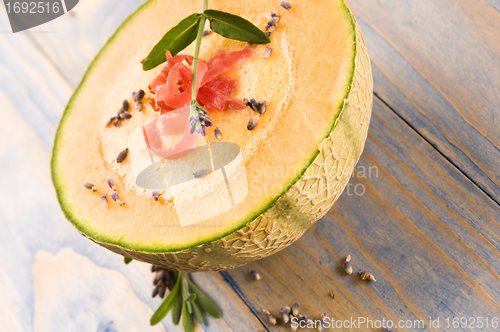 Image of fresh melon soup with parma ham and lavender flower