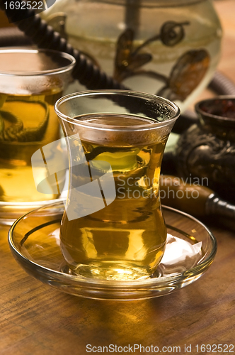 Image of Cup of turkish tea and hookah served in traditional style