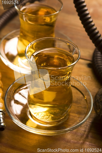 Image of Cup of turkish tea and hookah served in traditional style