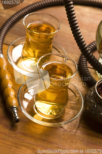 Image of Cup of turkish tea and hookah served in traditional style