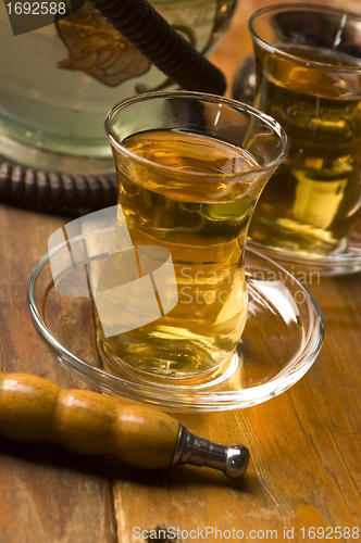 Image of Cup of turkish tea and hookah served in traditional style