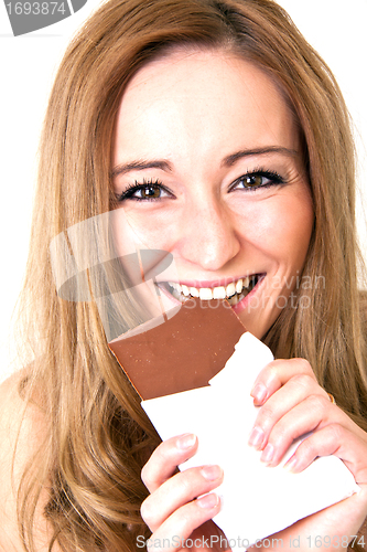 Image of young beautiful woman with a bright smile is eating chocplate