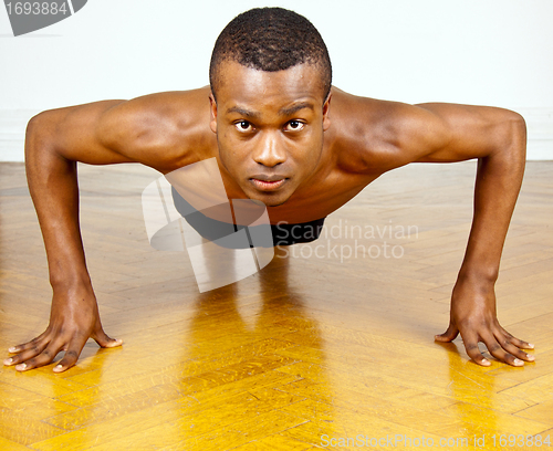 Image of young man with black skin ist doing fittness