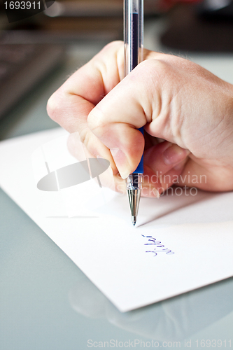 Image of womans hand is writing a letter with a pen 