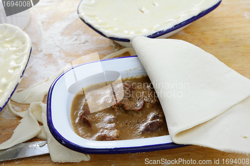 Image of Adding pastry to a pie