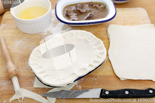 Image of Putting pastry on a pie