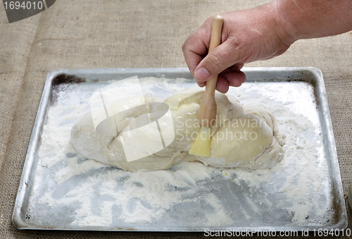 Image of Brushing egg on bread dough