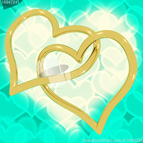 Image of Gold Heart Shaped Rings On Turquoise Bokeh Representing Love And