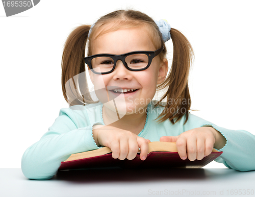 Image of Cute little girl reads a book