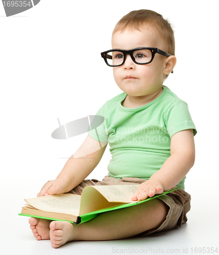 Image of Cute little boy reads a book