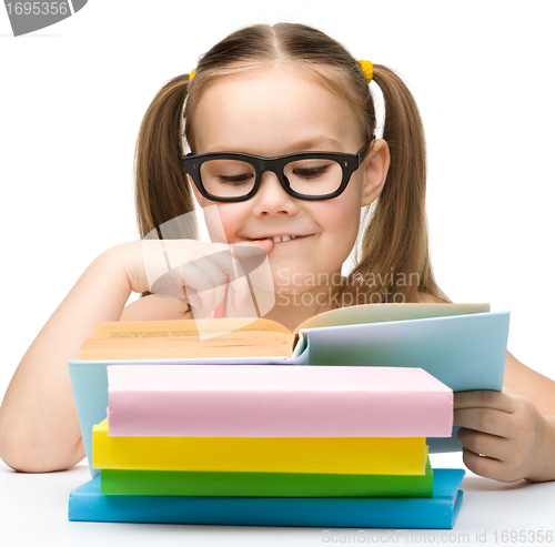 Image of Cute little girl is reading book