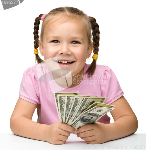 Image of Cute cheerful little girl with paper money