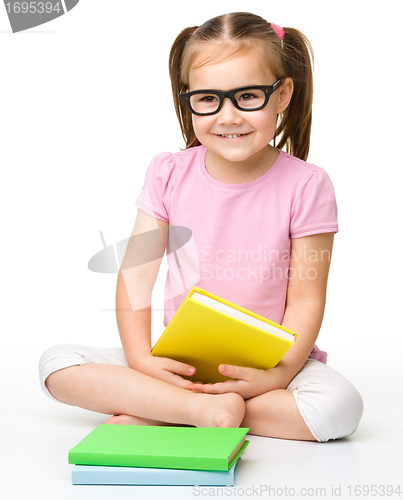 Image of Cute little girl reads a book