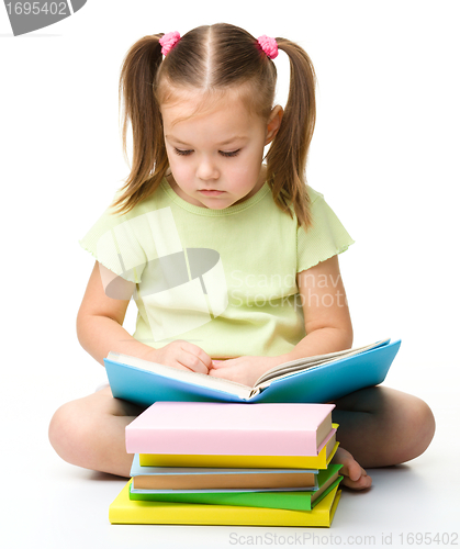 Image of Cute little girl reads a book
