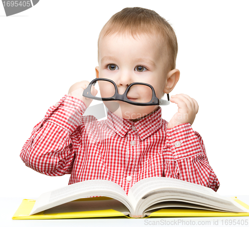Image of Cute little boy reads a book
