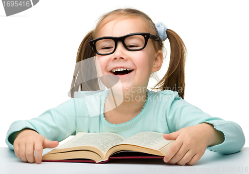 Image of Cute little girl reads a book