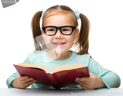 Image of Cute little girl reads a book
