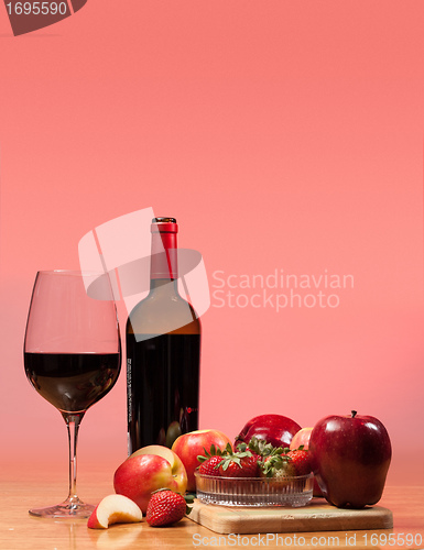 Image of Red wine bottle and fruit with glass