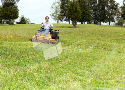 Image of Senior man on zero turn lawn mower on turf