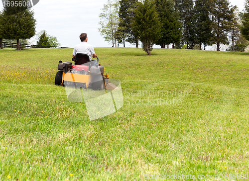 Image of Senior man on zero turn lawn mower on turf