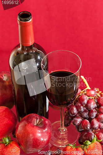 Image of Red wine bottle and fruit with glass