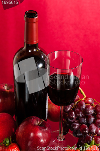 Image of Red wine bottle and fruit with glass