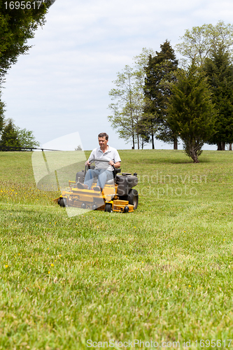 Image of Senior man on zero turn lawn mower on turf