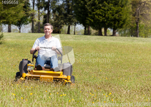 Image of Senior man on zero turn lawn mower on turf