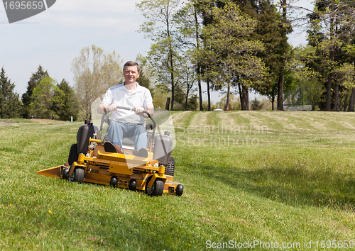 Image of Senior man on zero turn lawn mower on turf