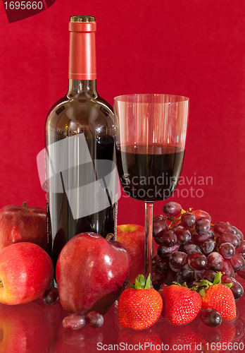 Image of Red wine bottle and fruit with glass