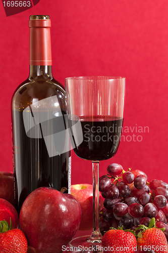 Image of Red wine bottle and fruit with glass