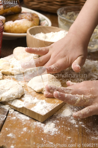 Image of Detail of hands kneading dough