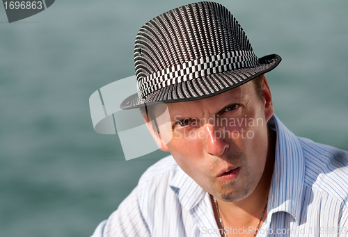 Image of portrait of a man in a hat amazed