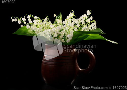 Image of Bouquet lilies of the valley in a ceramic mug.