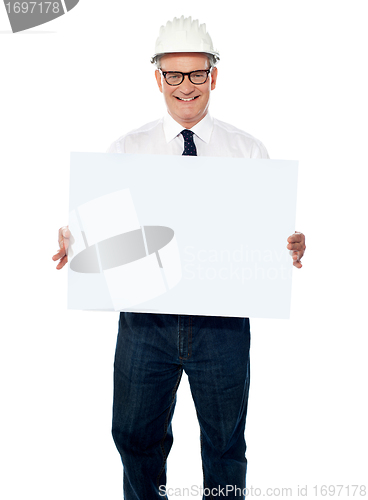 Image of Senior architect holding blank billboard