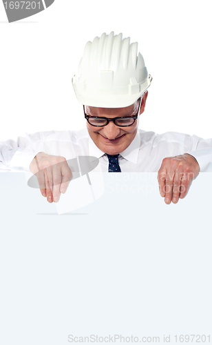 Image of Aged builder wearning and holding a blank poster