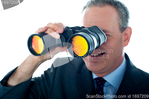 Image of Senior man observing through binoculars