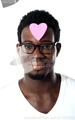 Image of Closeup of an african man with pink paper heart on forehead