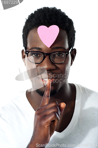 Image of Man with pape heart on forehead gesturing silence