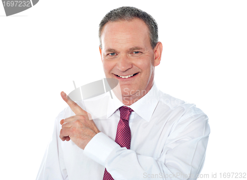 Image of Smiling businessman pointing away