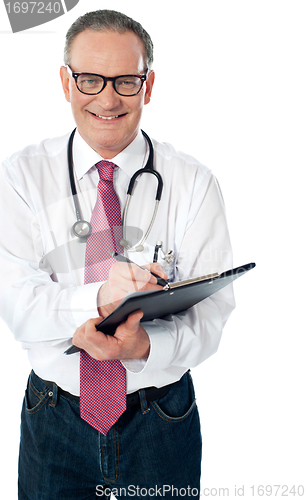 Image of Happy smiling matured doctor writing on clipboard