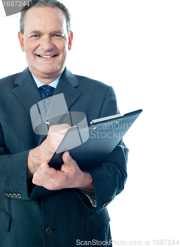 Image of Businessman writing on clipboard